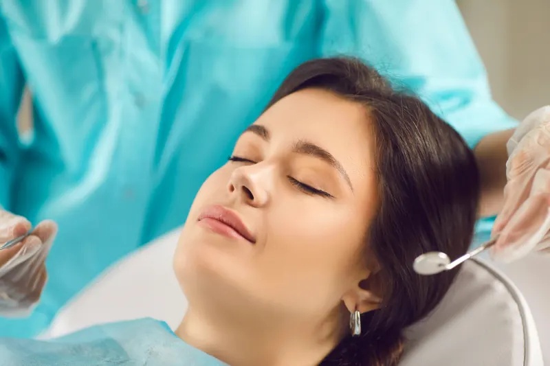 Relaxed patient sleeping peacefully through sedation dentistry treatment